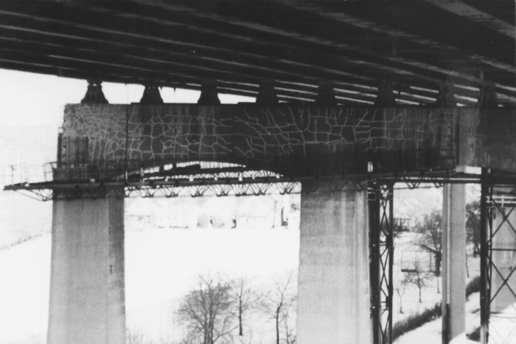 Photo of underneath a bridge | Beton Consulting Engineers The crack pattern in this concrete bridge pier indicates several different cracking modes.
