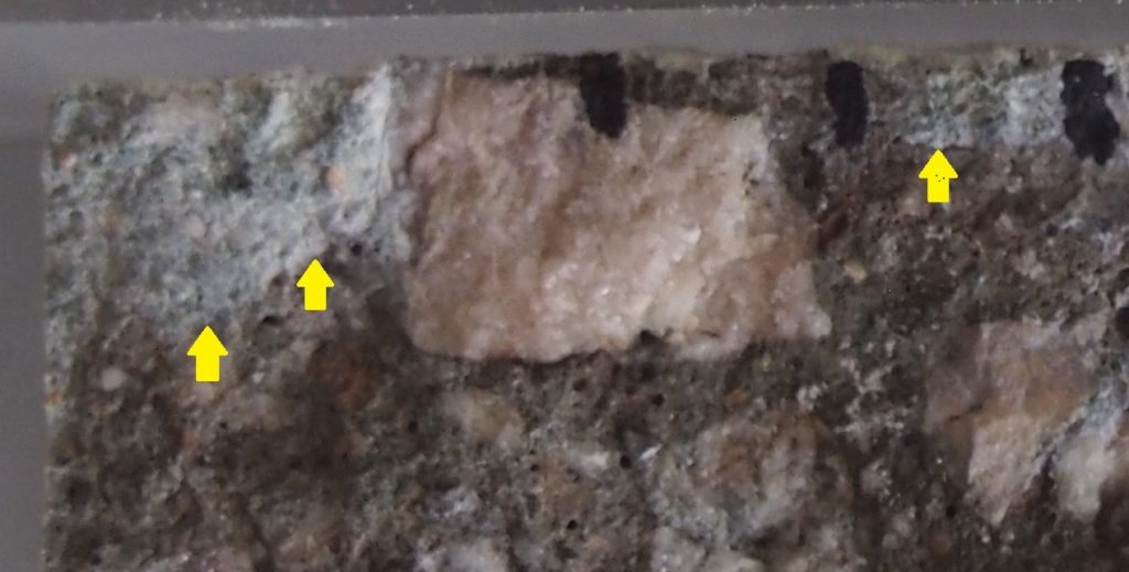 White silver chloride deposits on a split concrete test specimen