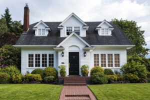 Shutterstock photo of a white clapboard single-family house with a brick walkway.