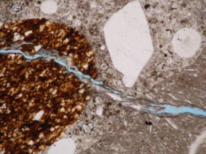 photomicrograph of reactive aggregate in concrete with cracking due to alkali-silica reaction